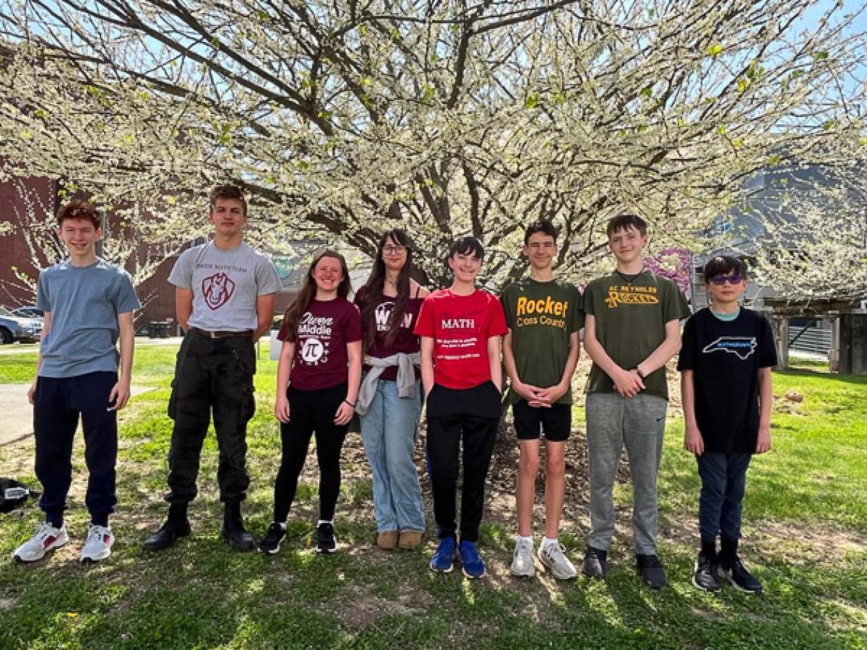 MathCOUNTS competitors pose in front of a flowering tree.