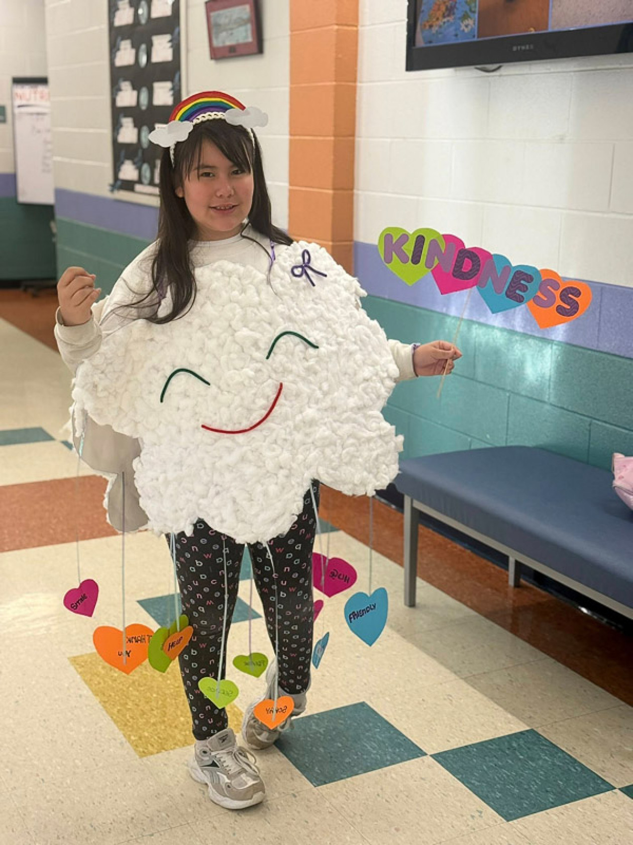 A girl with a smiling cloud costume and a sign with the word 