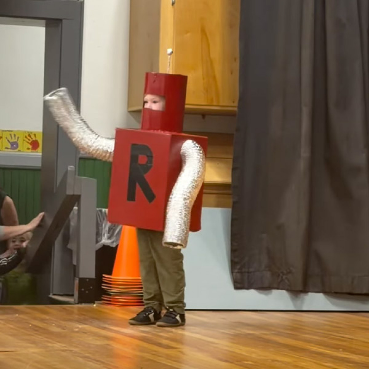 A boy dressed as a robot with the letter 