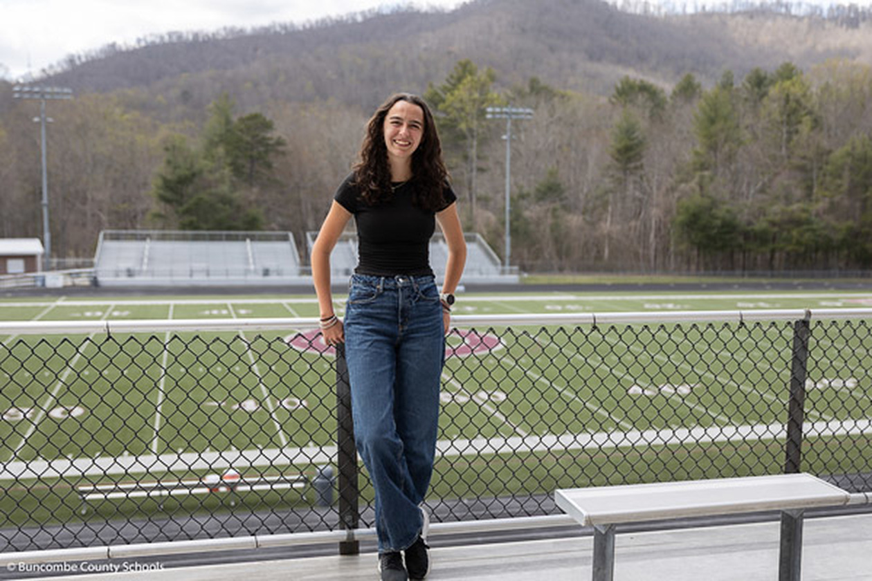 Jordan Robertson poses against a fence in front of the Owen High football field.