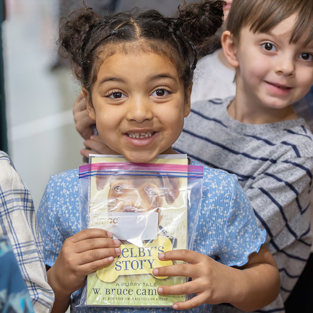 A girl smiles while holding the book 