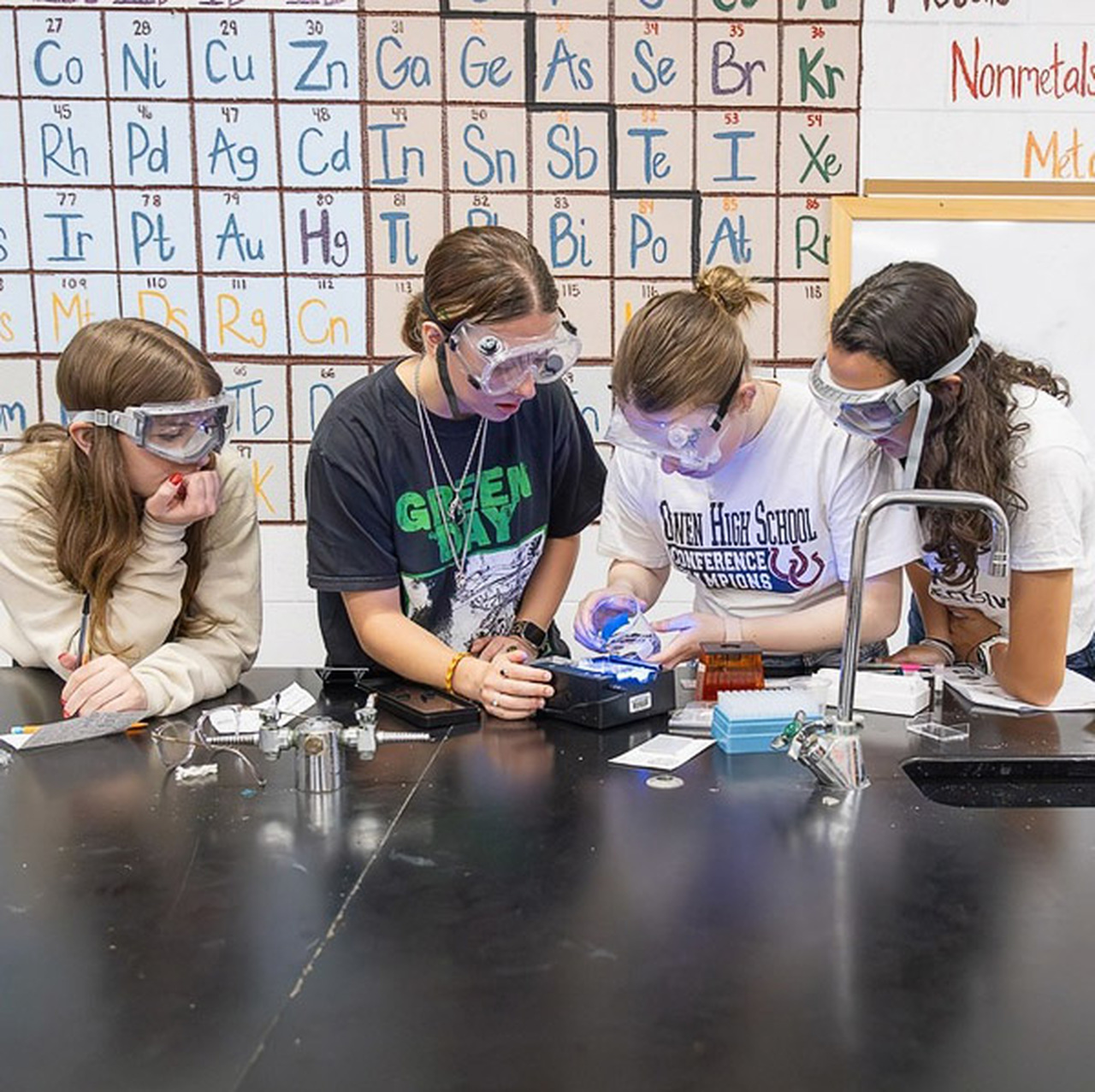 Four students work on a DNA project in a science lab.