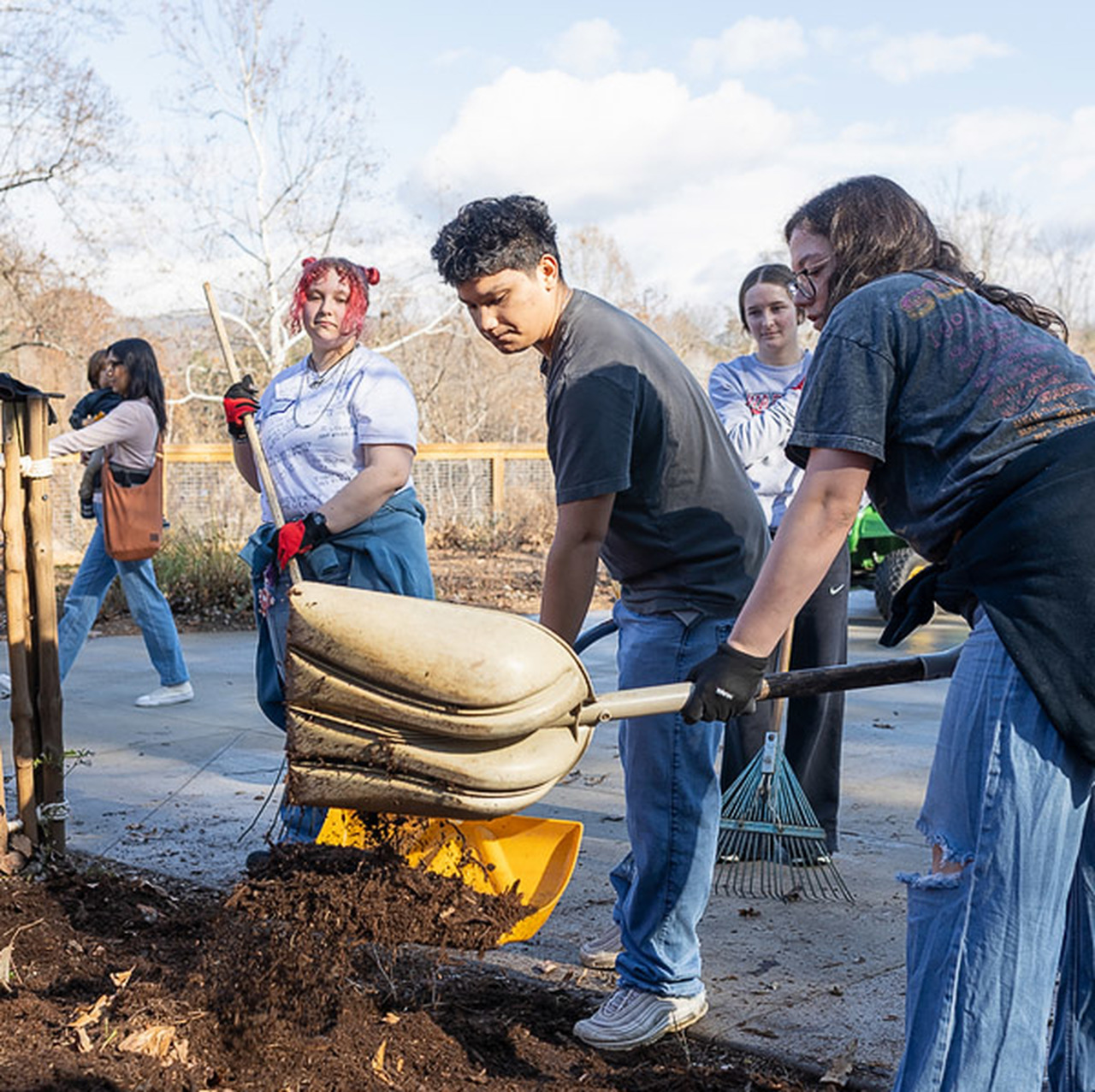 Student shovel mulch into a garden area at WNC Nature Center.