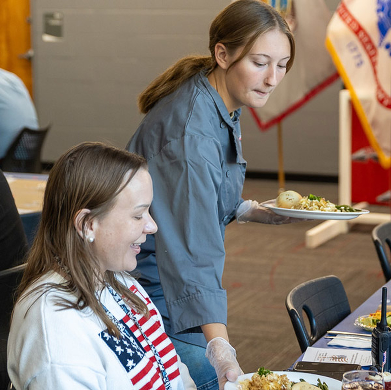 An Erwin High student serves a meal to a veteran.