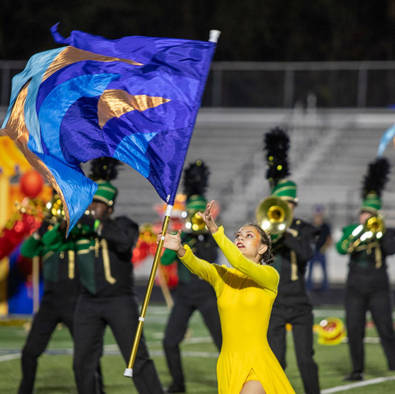 A Reynolds High color guard performer twirls a flag.