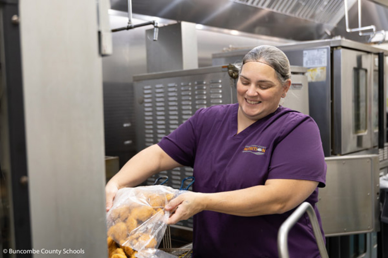 Child Nutrition Manager Serena Hanson prepares chicken nuggets.