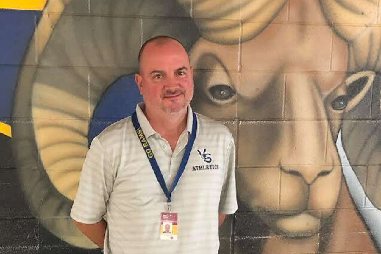 alley Springs Middle School boys and girls soccer coach Allan Tenney poses in front of a Ram mural.
