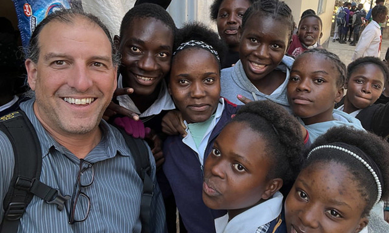Mr. Dezio takes a selfie with a group of students.