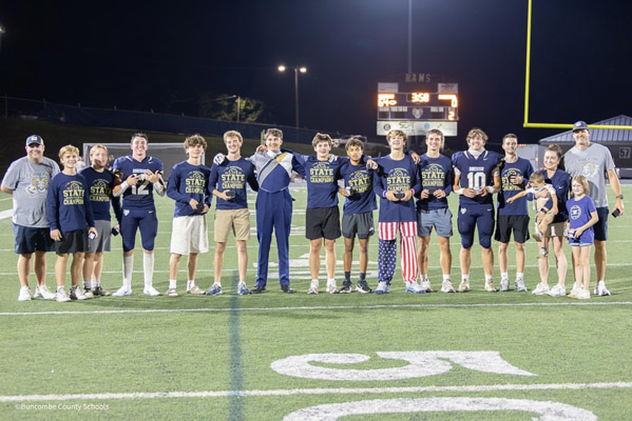Roberson men's volleyball players pose on the football field.