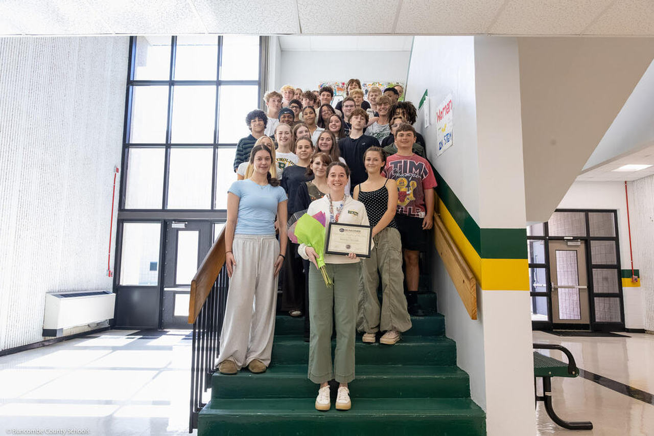 Annali Silver poses with one of her classes on a stairwell.