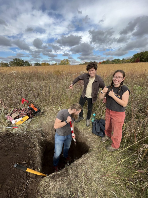 Students from Dan Maxbauer’s 2024 soils class pose with their pit in the Arboretum prairie