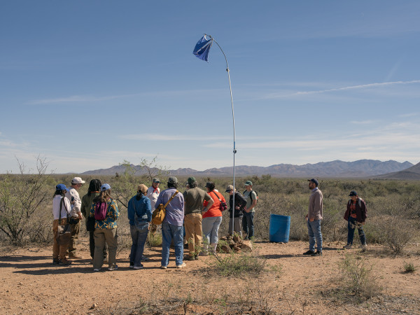 Trip members look towards a mountainous landscape