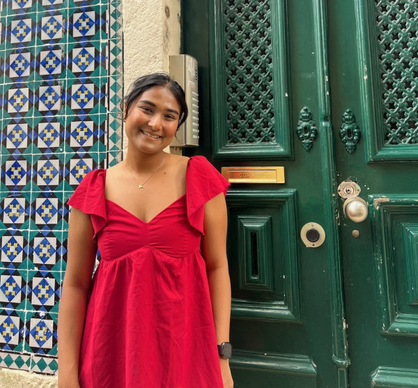Narjis Nusaibah in a red dress in front of a green door