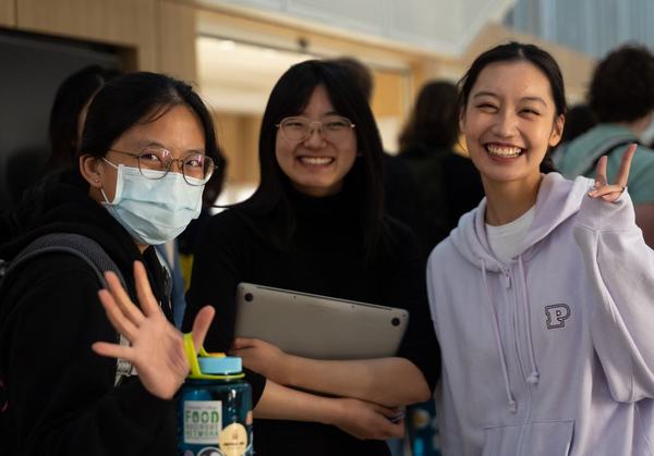 Three female STEM students smile at the camera