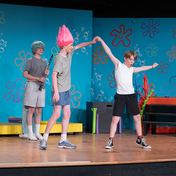 Three students perform during a dress rehearsal for 