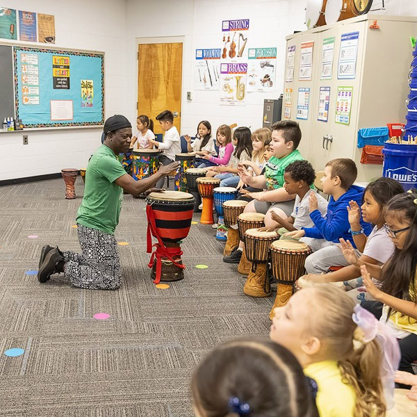 Adama Dembele leads students through a hand drum lesson.