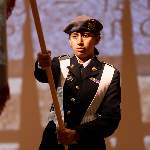 A JROTC cadet holds a flag during the ceremony.