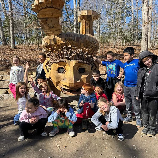 Students pose in front of one of the troll sculptures.