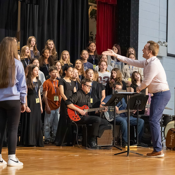 Middle School all-county chorus performers warm up on stage before the show.