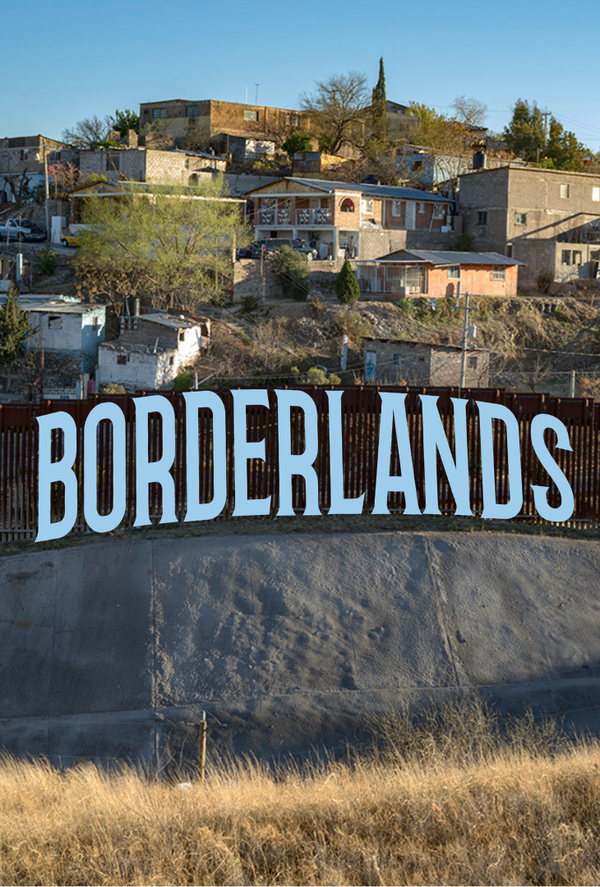 Borderlands text written over fence with houses behind it on a hill