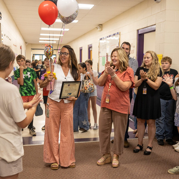 Marilynn Whitcher reacts to students cheering in the hallway.