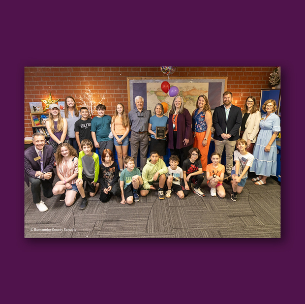 The Surprise Squad joins Donalyn Small, school leaders, and students for a photo.