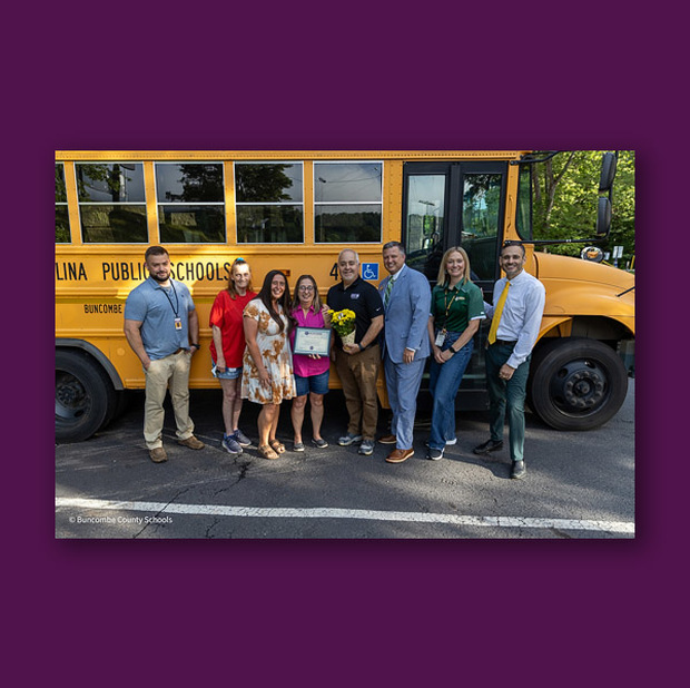 Frances Hyatt poses in front of her bus with A.C. Reynolds High School and district leaders.